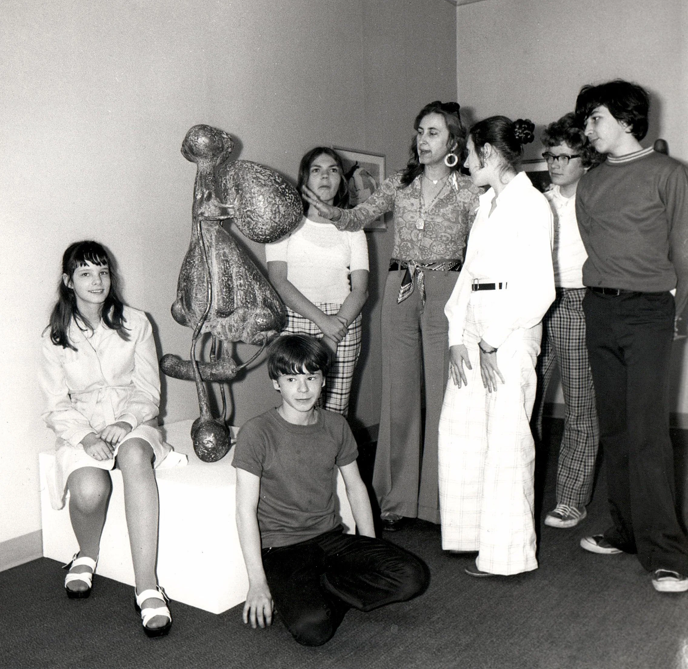 Visitors, including several children, viewing a bronze sculpture at an early UIMA exhibition, 1970s