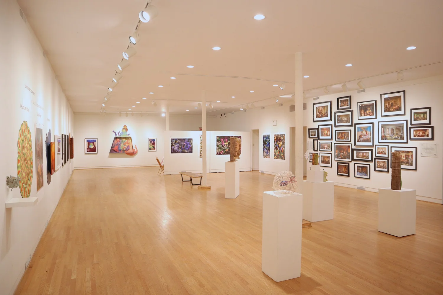 Interior of the UIMA gallery, with framed prints along the walls and sculpture displayed on pedestals