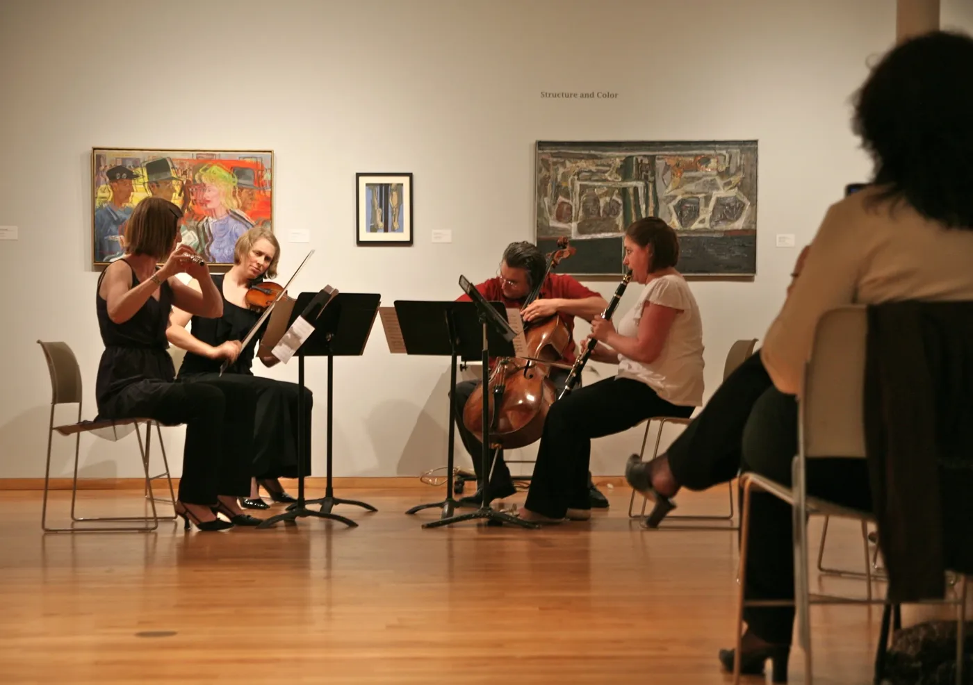 The Maverick Ensemble performing a chamber music concert inside UIMA's gallery, surrounded by paintings from the Structure and Color exhibition