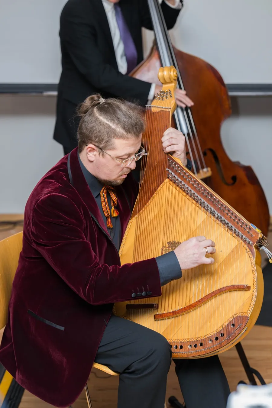 A bandura player in a velvet jacket performing alongside an upright bass, 2019